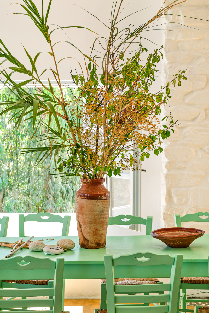 Vase with greenery on green table at Maremma Paros restaurant.